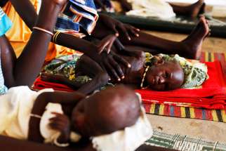 Malnourished children lie next to their mothers July 15, 2014 at the Medecins Sans Frontieres Hospital in Leer, Sudan. 