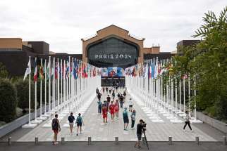 People walk through the Olympic village in Paris July 23, 2024.