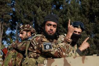 Rebel fighters gesture, after rebels seized the capital and ousted President Bashar Assad, in Damascus, Syria, Dec. 9, 2024.