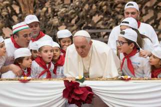 Pope Francis blows a candle on his four-metre long pizza surrounded by his special guests pizza at St. Peter&#039;s Square Dec. 17. 