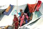 Children displaced by flooding stand outside their family tent while waiting for food handouts and relief material in Sehwan, Pakistan, Sept. 14.