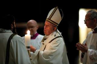 Pope Francis lights the paschal candle at the start of the Easter Vigil in St. Peter’s Basilica April 11, 2020.