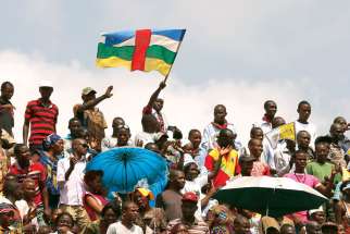 A man waves the national flag of the Central African Republic as Pope Francis celebrates Mass in Barthelemy Boganda Stadium in Bangui, Central African Republic, Nov. 30. 