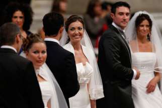 Newly married couples react after exchanging vows in St. Peter’s Basilica at the Vatican Sept. 14, 2014. Among those married were couples who already had children or have lived together before marriage. 