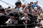 Syrian refugees wait on the Syrian side of the border near Sanliurfa, Turkey in this picture dated June 10.