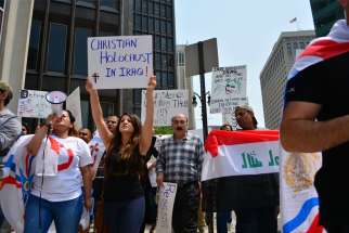 Protesters display signs and carry flags during a 2014 protest in Detroit, calling on the U.S. to intervene in the persecution of Christians in Iraq.