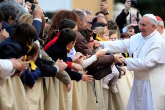 Pope Francis greets the faithful as he arrives at the Our Lady of Providence Center in Rome April 17, 2015. Vatican officials announced the Pope will celebrate the Holy Thursday Mass of the Lord&#039;s Supper with young refugees in Castelnuovo di Porto, about 15 miles north of Rome.