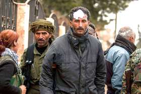 A member of the Kurdish Security Forces, above, holds an injured civilian to evacuate him in Tal Tamar, Syria, Feb. 25.