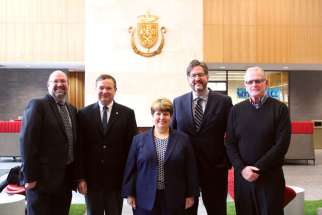 Michael Pautler, left, executive director of the Institute of Catholic Education, visited with the staff of King’s University College.