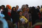 Iraqi refugees line up to receive free food inside the Khazer camp on the outskirts of Irbil, Iraq, June 29. Archbishop Bashar Matte Warda of Irbil told Catholic New Service by telephone June 28 the situation was going &quot;from bad to worse.&quot;