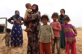 A displaced Syrian family who fled violence in Aleppo stands in a field in the rural area of Manbij in 2016. Amid the destruction in war-torn Syria, a community of Discalced Carmelites in Aleppo perseveres in its mission of continuous prayer and help to families in need.