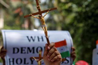 A woman holds a cross during a May 3 protest in Mumbai, India, organized by various Catholic organizations against what they say is an illegal demolition of a cross by a municipal body.