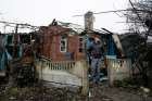  A man stands in front his damaged house after shelling March 24 in the Ukrainian town of Makeevka.