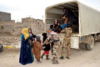 Iraqi soldiers evacuate families from Ramadi, Iraq, Feb. 3, after the city was recently recaptured by Iraqi forces. A European bishops’ commission has welcomed a move by the European Parliament to classify atrocities and religious cleansing by the Islamic State as genocide. Canada has been asked to follow suit but has not done so to date.