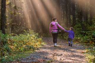 A mother and daughter walking in a forest in Maple Ridge, Canada. 