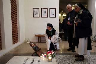  Nuns and others stand next to a photograph of Bishop Pierre Claverie at his grave in St. Mary&#039;s Cathedral, where a vigil was held, in Oran, Algeria, Dec. 7. The vigil was to prepare for the Dec. 8 beatification of Bishop Claverie and a group of 18 others, who were martyred in the course of the Algerian civil war. 