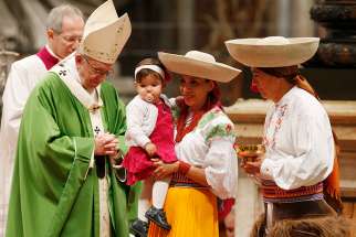 Family members bring up the offertory gifts as Pope Francis celebrates Mass marking the World Day of Migrants and Refugees in St. Peter&#039;s Basilica at the Vatican Jan. 14. 