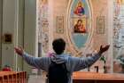 A man raises his arms in prayer at the Church of Santa Maria delle Grazie al Trionfale in Rome March 17, 2020. Many churches in Italy remain open for prayer amid a nationwide lockdown to prevent the spread of the coronavirus.