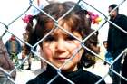 A displaced Syrian girl finds temporary shelter at a school in Damascus, Syria.
