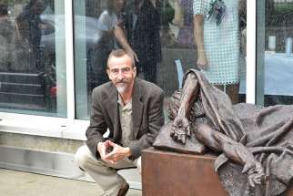 Ed Czuchnicki poses with Timothy Schmalz’s When I Was Sick You Visited Me sculpture outside St. Joseph’s Hospital in Hamilton.
