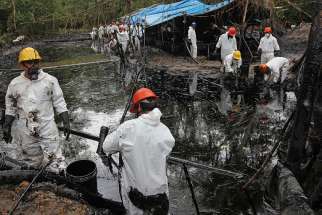 Workers collect oil from a stream below the site of an oil pipeline break in 2016 in Wachapea, Peru. A Peruvian court has upheld the right of Awajun and Wampis indigenous communities to be consulted about oil drilling on their land.