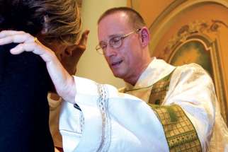 Deacon Stephan Brunck blesses a parishioner at St. Paul’s Basilica in Toronto.
