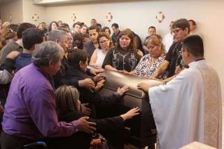 Family and friends of slain journalist Javier Valdez touch his coffin during his May 17 memorial service in Culiacan, Mexico. Valdez was pulled from his car and shot twelve times May 15 in Culiacan, a city currently consumed by drug cartel violence.