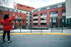 A woman waves to residents standing in the windows at the Cardinal Ambrozic Houses of Providence in Toronto on April 7. Like many long-term care facilities, it has been hit by COVID-19 infections.