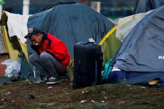  A Venezuelan migrant brushes his teeth outside his tent at a makeshift camp Nov. 26 in Bogota, Colombia. The United Nations estimates there are more than 258 million migrants around the world living outside their country of birth. 
