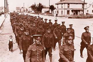 A young child marches alongside Canadian soldiers preparing to be sent off to the First World War. At right is Jesuit Rev. Major William Hingston, who was a chaplain in the Canadian Expeditionary Force during the war.