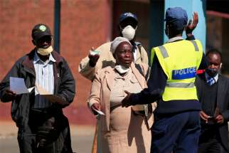 A policewoman turns away people from the city center ahead of planned anti-government protests in Harare, Zimbabwe, July 30, 2020.