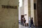 A sign displays the tribunal court location, as people walk along a corridor at Milan Court of Justice, Italy, April 26, 2024. A Sister of Charity in northern Italy was placed under house arrest after a nearly four-month investigation by prosecutors revealed she allegedly used her prison ministry to connect local mafia bosses with inmates.