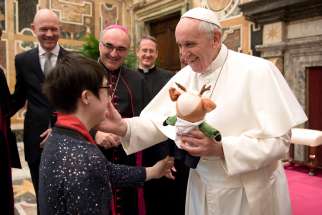 Pope receives a stuffed animal from a participant in the Special Olympics during a meeting Feb. 16 at the Vatican. The athletes and organizers were at the Vatican to promote the Special Olympics World Winter Games, which will be held in Austria March 14-25. 