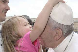 Little Estella steals Pope Francis&#039; zucchetto as he gives her a kiss during his weekly general audience March 22.