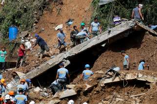Rescue workers and volunteers search for buried villagers Sept. 16 after Typhoon Mangkhut hit Itogon, Philippines. Villagers had taken shelter in an abandoned mine shaft that collapsed.