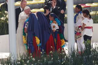 Pope Francis greets girls in traditional dress during a meeting with young people at the Jose Maria Morelos Pavon Stadium in Morelia, Mexico, Feb. 16.