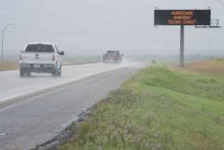 Motorists traveling south on Interstate 37 pass a traffic sign warning of weather conditions Aug 25 in Corpus Christi, Texas. Hurricane Harvey was &quot;dangerously approaching the Texas Coast&quot; Aug. 25 and expected to drop as much as 35 inches of rain and usher in &quot;life-threatening&quot; storm-surge flooding upon landfall late Aug. 25 or early the next morning, the National Hurricane Center said.