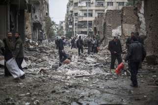 Syrians look at a destroyed field hospital in the rebel-held area of Douma on the outskirts of Damascus, Oct. 29, 2015. Christian patriarchs residing in Damascus urged the international community to &quot;stop the siege of the Syrian people&quot; and to lift international sanctions, which they say are deepening the suffering.