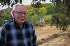 Herb Muma stands at the foot of the grave markers for Oblate priests who were key players in the history of southern Saskatchewan. 