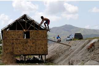 A man fixes the roof of damaged house on Samar Island, Philippines, Dec. 9. The Philippine Red Cross confirmed that Typhoon Hagupit killed at least 22 people. 