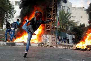 A Palestinian hurls a stone toward Israeli troops during a clash near the West Bank city of Nablus Dec. 29. Demonstrations are against President Donald Trump&#039;s decision to recognize Jerusalem as the capital of Israel.