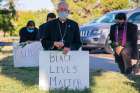 Bishop Mark J. Seitz kneels at Memorial Park in El Paso, Tex.