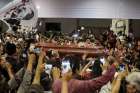 People react as the coffin holding the body of former Peruvian President Alan Garcia arrives at the APRA party headquarters April 18, a day after he died of a gunshot wound believed to be self-inflicted. 