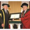 St. Jerome’s University chancellor James Beingessner, left, presents an honorary doctorate to Douglas Roche June 14 at the school’s convocation.