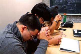 Members of Ryerson University Catholic Students’ Association close their weekly meeting at the university’s library with a prayer from the Exodus 90 program. Front to back are Ian Beveridge, Judel Villardo and James Delos Reyes. 