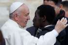 Pope Francis greets a man as he meets individuals with disabilities during his general audience in St. Peter&#039;s Square at the Vatican Nov. 15. 