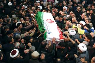 Mourners touch the casket of Iranian Maj. Gen. Qassem Soleimani during his funeral procession in Tehran Jan. 6, three days after he was killed in a U.S. drone airstrike.