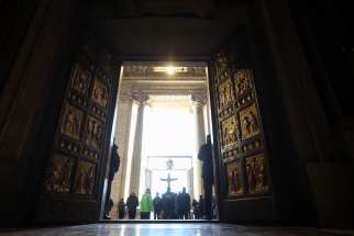 A group of pilgrims prays before passing through the Holy Door of St. Peter’s Basilica on Christmas Day, Dec. 25, 2024, after it was opened by Pope Francis during Christmas Mass the night prior to mark the start of the Holy Year 2025.