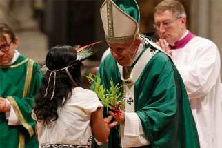Pope Francis accepts a plant during the offertory as he celebrates the concluding Mass of the Synod of Bishops for the Amazon at the Vatican Oct. 27, 2019.