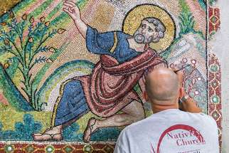 A restorer works on a wall of mosaic tiles in the Church of the Nativity in Bethlehem. 
